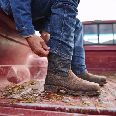 Cowboy on truck bed pulling on DDB0366 Maverick XP work boot